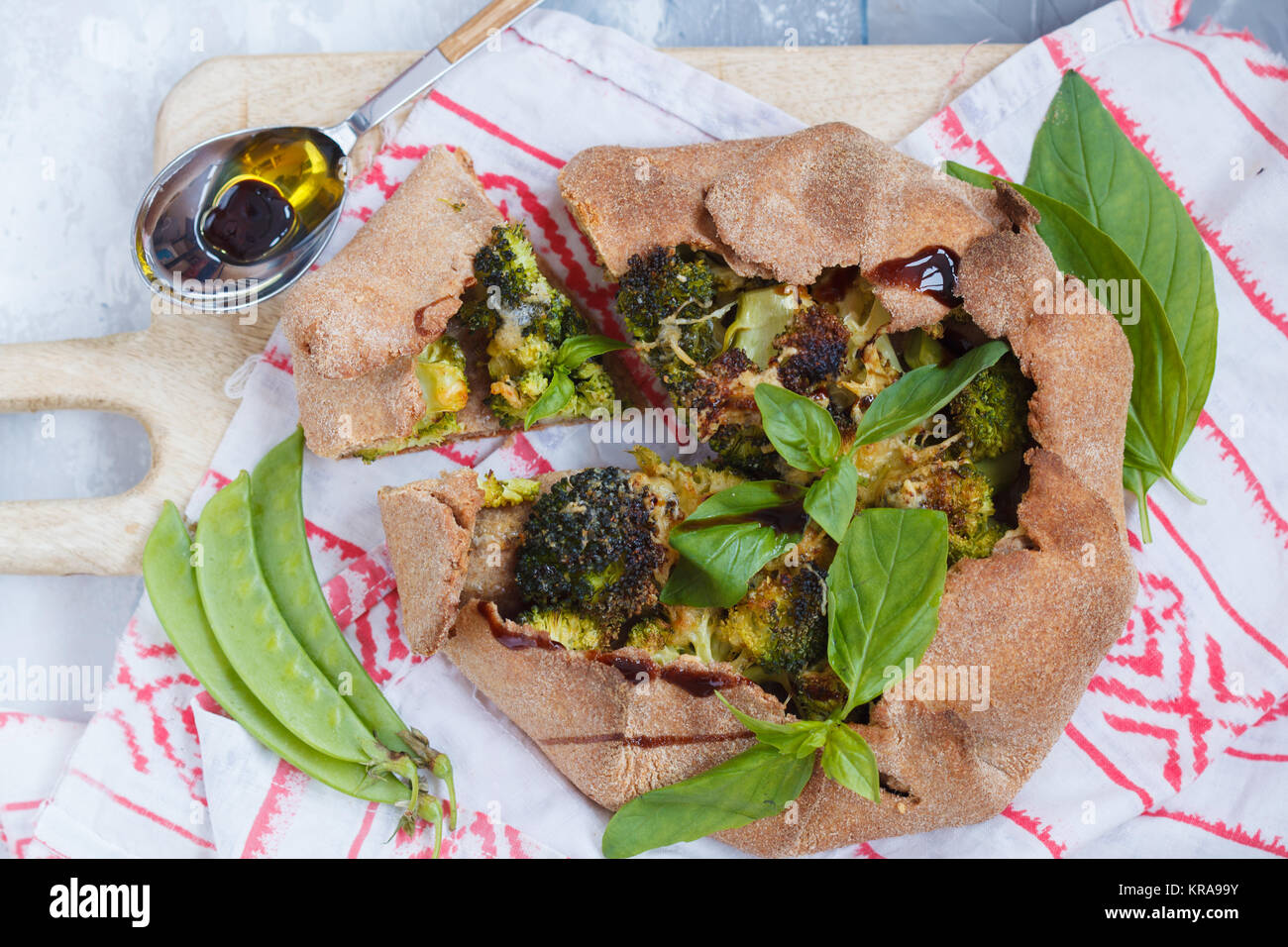 Vegetarische Crostata oder Galette mit Brokkoli, Erbsen, Basilikum und Balsamico. Gesunde vegane Ernährung Konzept. Stockfoto