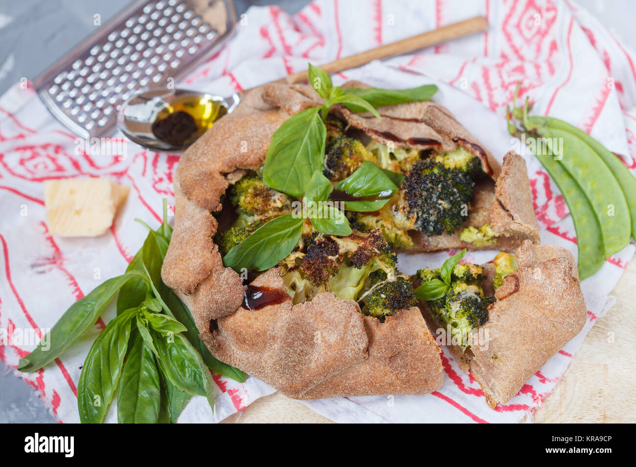 Vegetarische Crostata oder Galette mit Brokkoli, Erbsen, Basilikum und Balsamico. Gesunde vegane Ernährung Konzept. Stockfoto