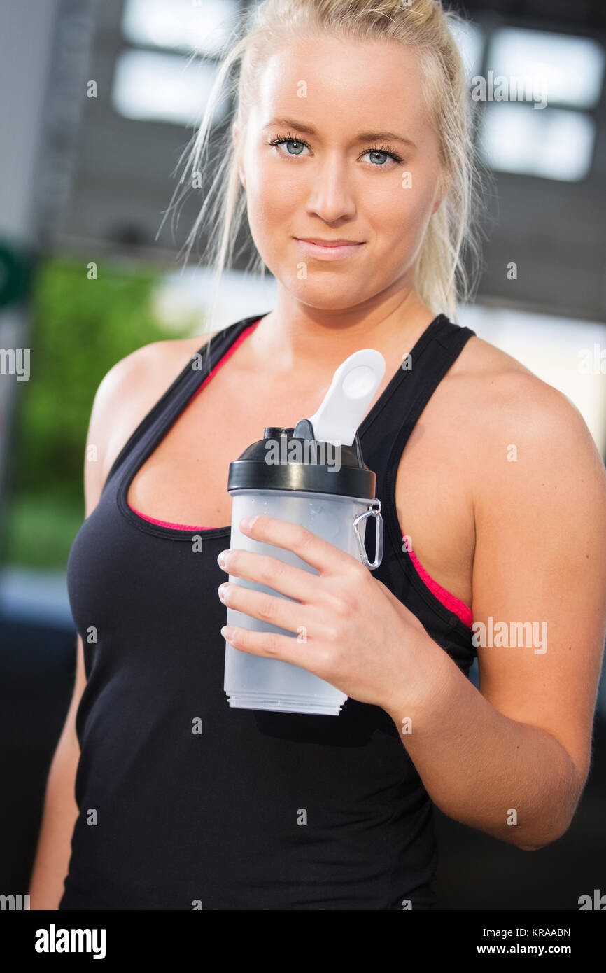 Portrait von Frau Ruhe und trinken Wasser bei Fitness Gym Stockfoto