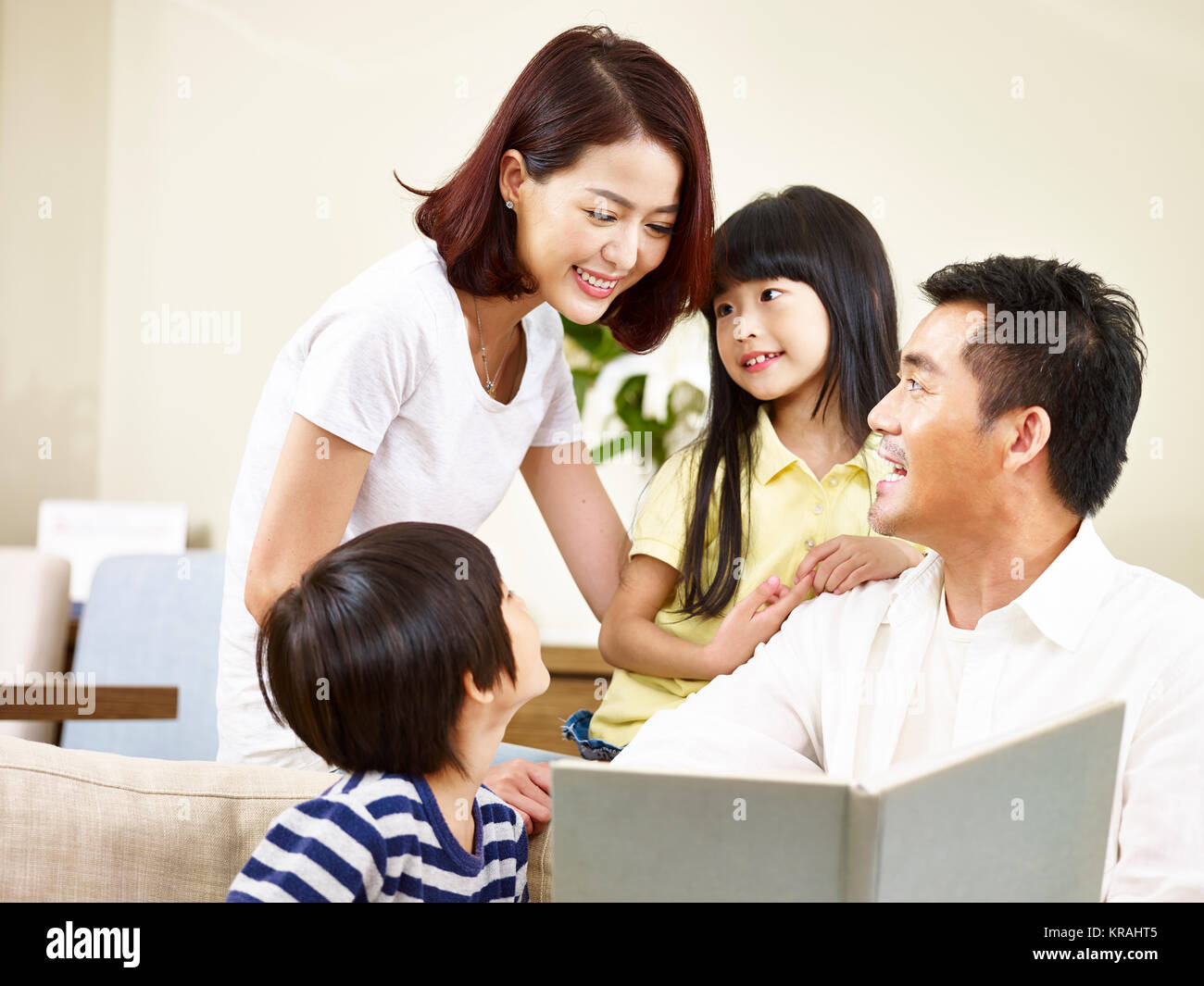 Asiatische Eltern Vater und Mutter und zwei Kinder, Sohn und Tochter, ein Buch lesen, eine Geschichte zu erzählen. Stockfoto
