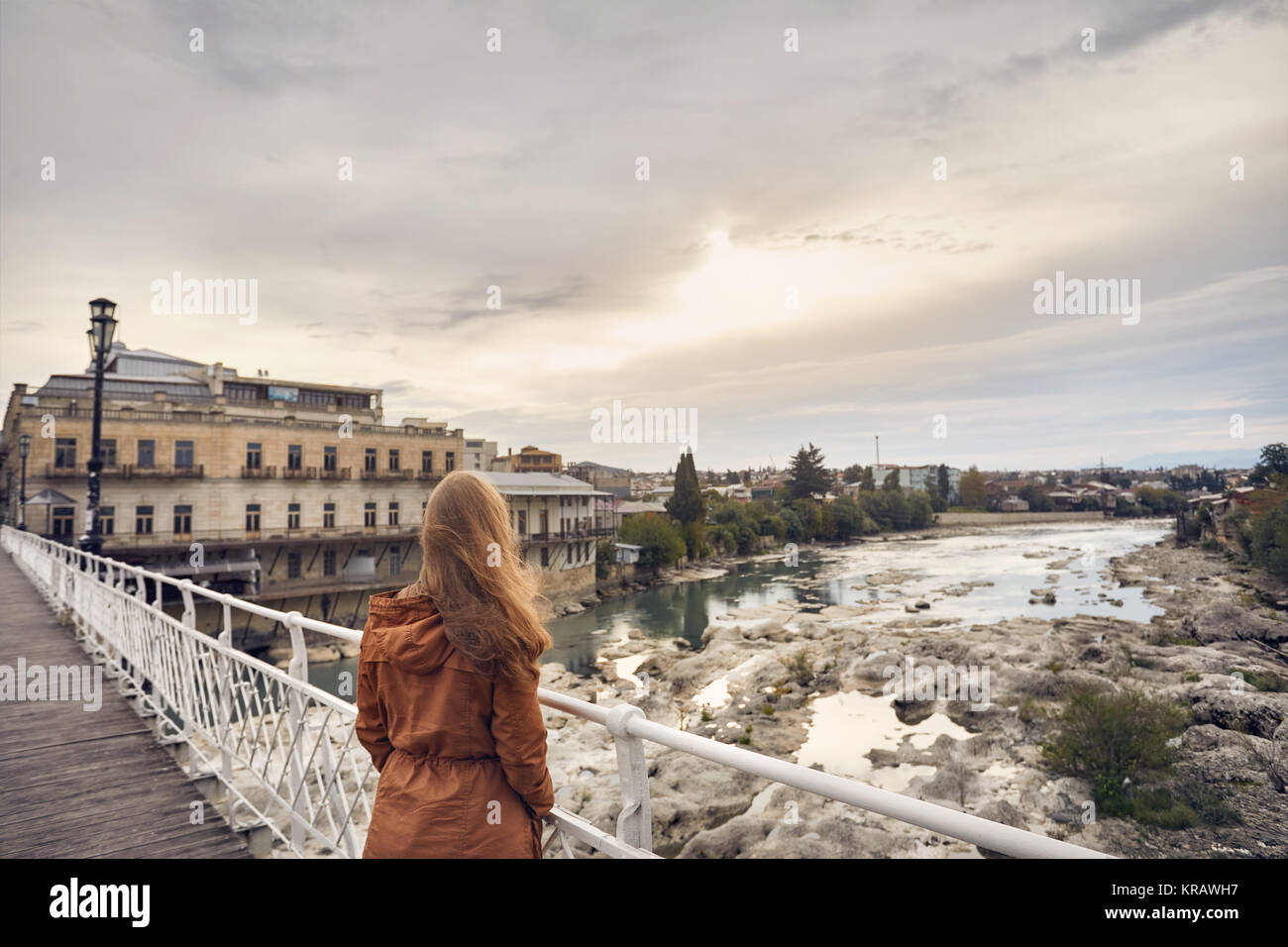 Einsame Frau mit langen Haaren auf der Brücke bei Sonnenaufgang in Kutaissi, Georgien suchen Stockfoto