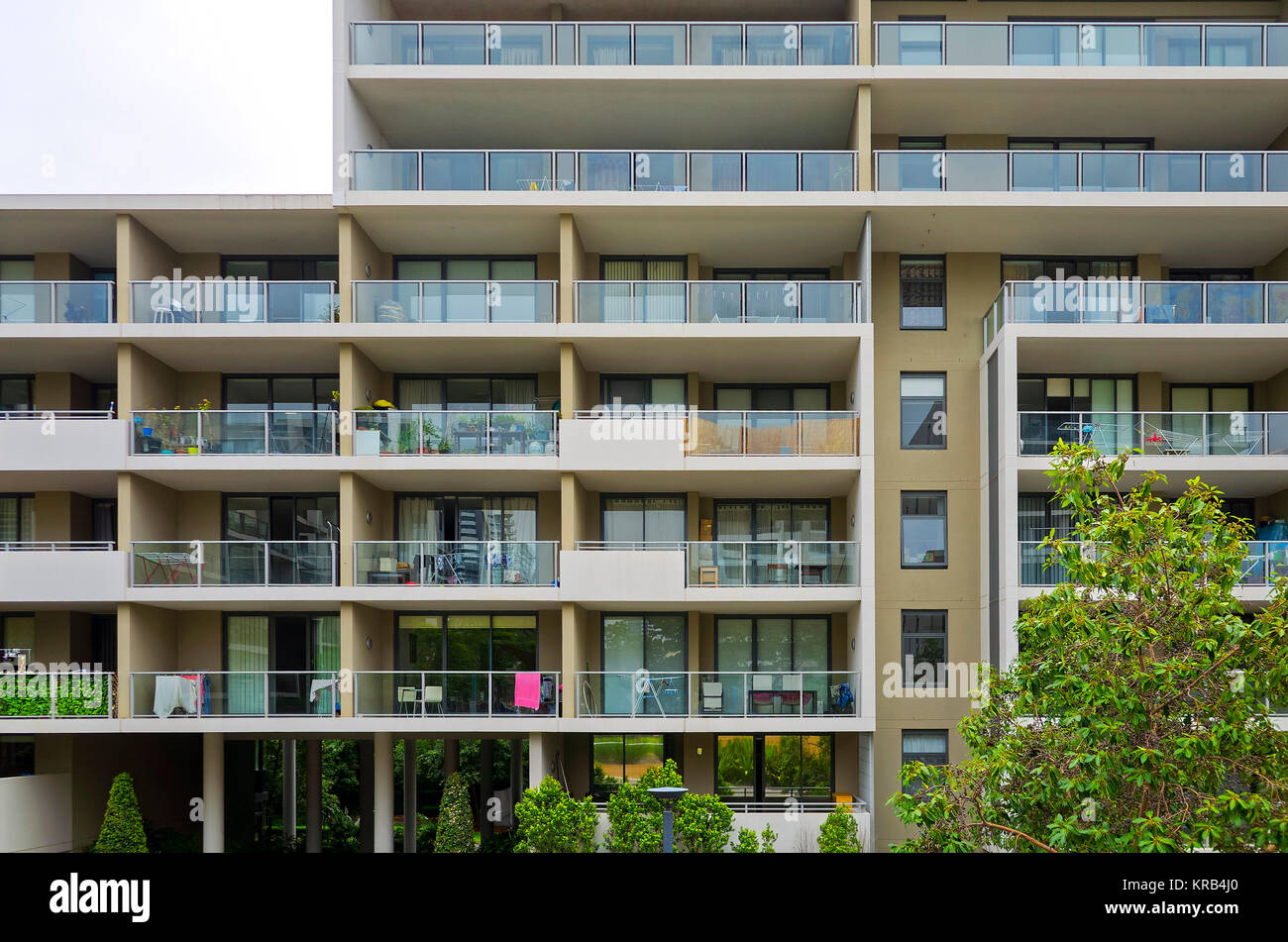 Modernes Wohnhaus außen closeup mit Bäumen. Apartment Gebäude mit Fenstern und Balkonen. Architektur Detail in Rhodos, Sydney, Austral Stockfoto