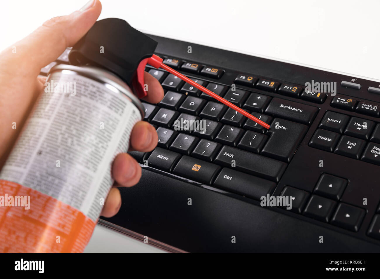 Reinigung Staub von Computer Tastatur mit Druckluft Reiniger Stockfoto