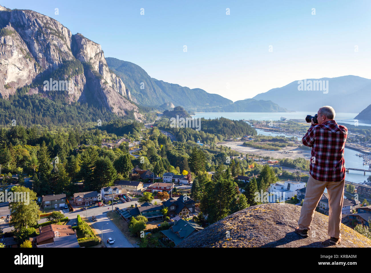 Ältere Erwachsene Touristen fotografieren von Rauch Bluffs Park mit Blick auf die Howe Sound und der Stawamus Chief in Squamish, British Columbia, Kanada. Stockfoto