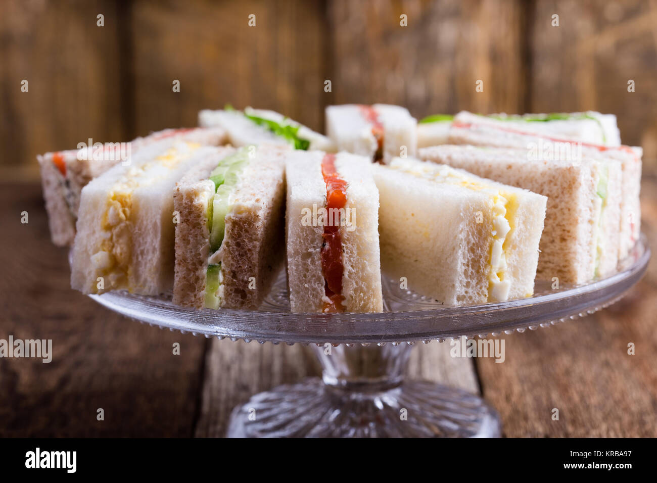 Englischer Tee mit Sandwiches, Kuchen über rustikal Hintergrund Stockfoto