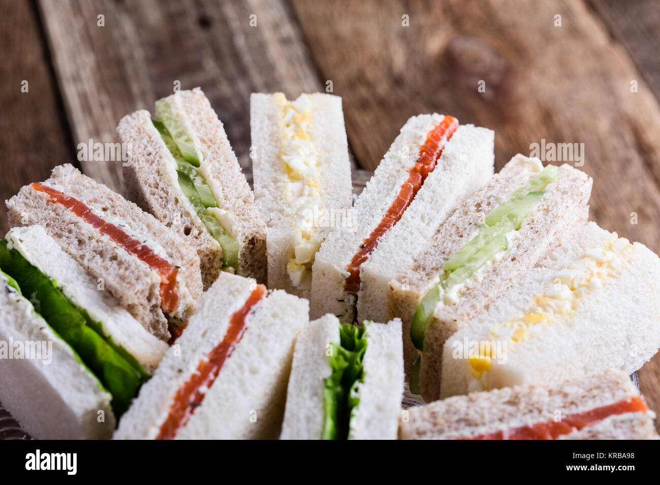 Englischer Tee mit Sandwiches, Kuchen über rustikal Hintergrund Stockfoto