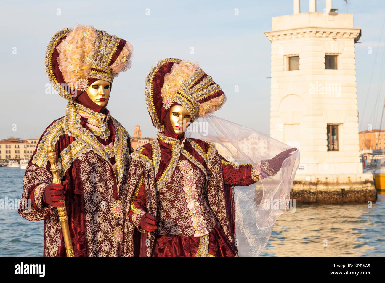 Karneval in Venedig, Venetien, Italien, Paar in reich bestickt rot Kostüme  im Santa Maria Giorgio Leuchtturm bei Sonnenuntergang posing  Stockfotografie - Alamy