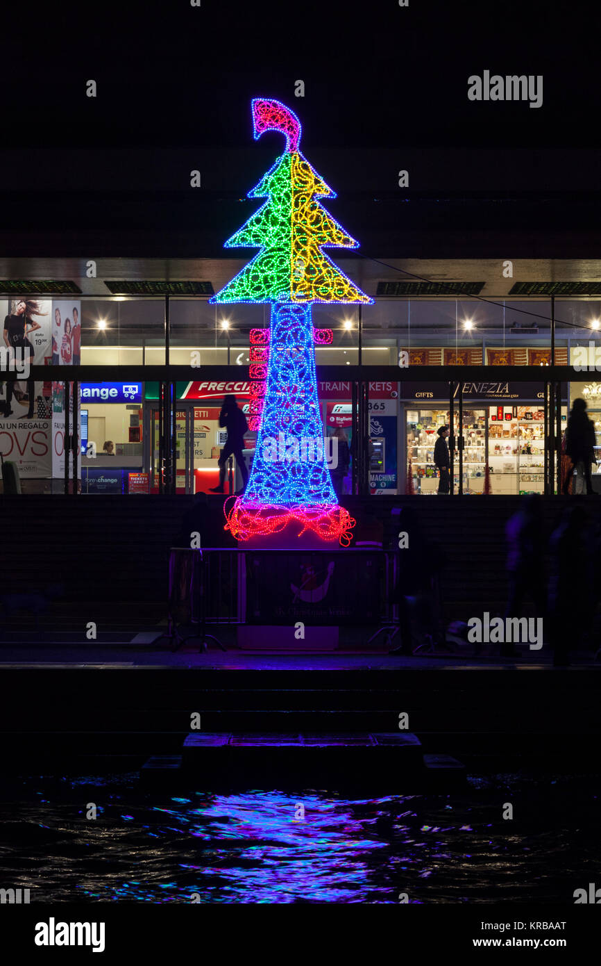 Weihnachtsbeleuchtung außerhalb von Santa Lucia, Venedig, Italien in Form von einem Weihnachtsbaum mit Gondel Ferro in den Grand Canal reflektiert in der Nacht Stockfoto