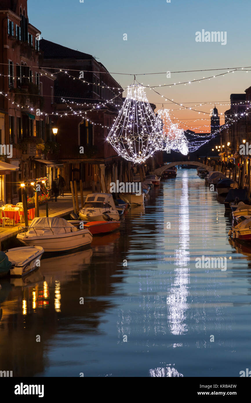 Weihnachtsbeleuchtung im Canal Vetrai, Murano, Venedig, Italien, Casting Sekt Reflexionen auf dem Wasser bei Sonnenuntergang Stockfoto