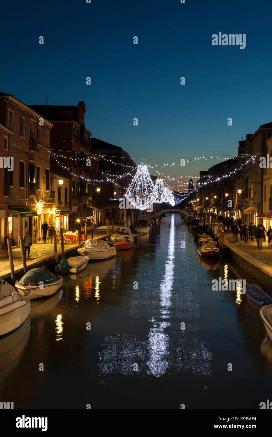 Weihnachtsbeleuchtung im Canal vetrai an der blauen Stunde, Murano Venedig, Italien mit funkelnden Lichtreflexe und Fußgänger auf der Fondamenta dei Vetrai Stockfoto