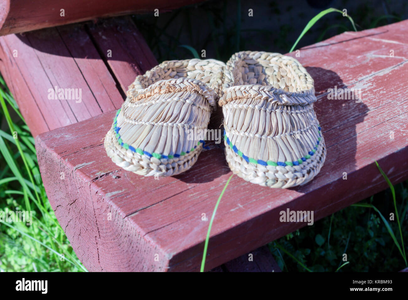 Wicker Schuhe auf hölzernen Haustür bei sonnigem Sommerwetter Stockfoto