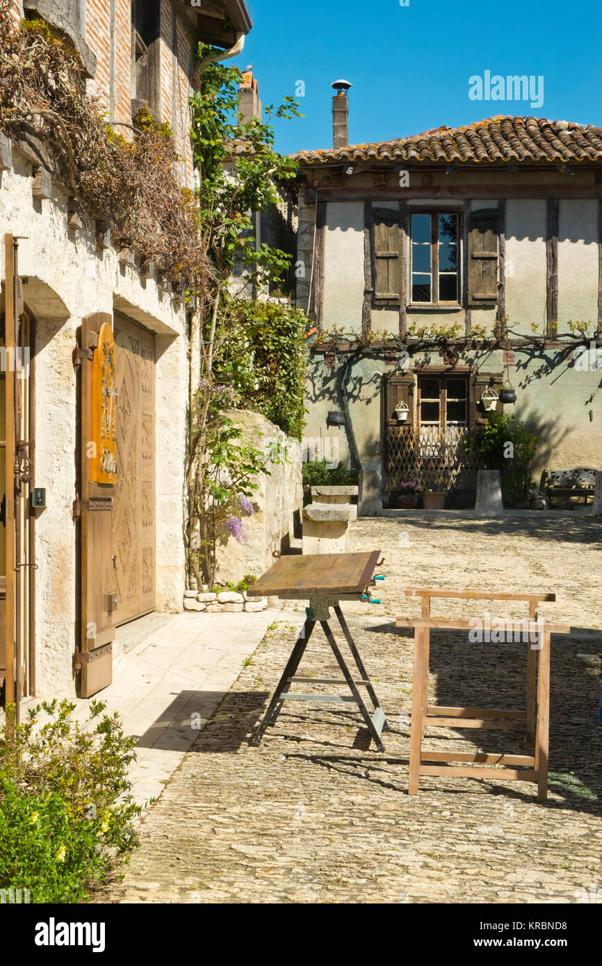 Traditionelle hölzerne Fensterläden, repariert und neu lackiert warten auf eine Werkbank außerhalb einer idyllischen alten Cottage in Pujols, Lot-et-Garonne, Frankreich Stockfoto