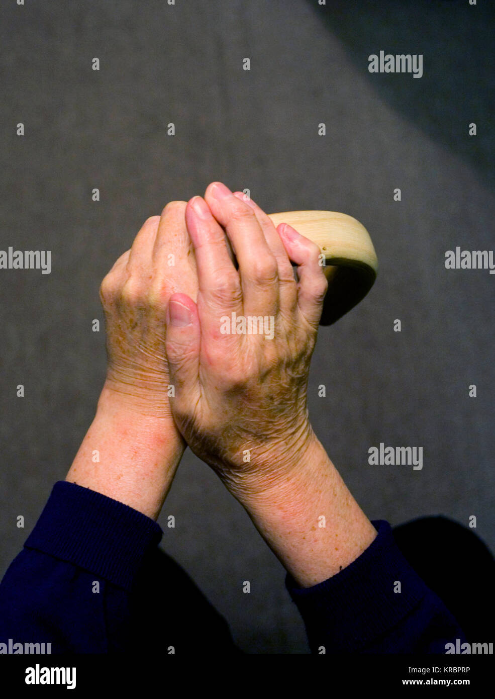 Die Hände von einer älteren Frau auf der einen und einem Spazierstock, in einem gestellten Foto, in Harlow, Großbritannien zum 17. Dezember 2017 Stockfoto