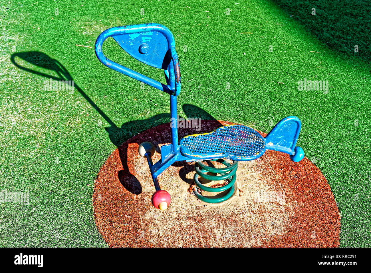 Blaue Feder Fahrt mit geschält Farbe und Licht blaue Flecken und Rost mit einem grünen Frühling und ein roter Teppich mit Sand auf es, eine einzigartige Form und einen Platz zum Stockfoto