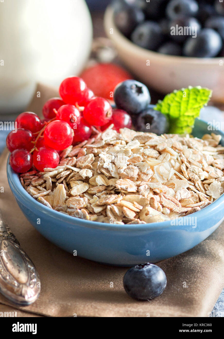 Haferflocken in eine Schüssel mit Beeren und Milch Stockfoto