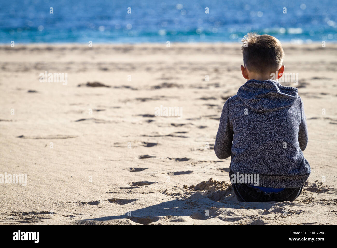 Traurig Allein Junge Sitzt Am Strand Blick Auf Meer Und Denken Stockfotografie Alamy