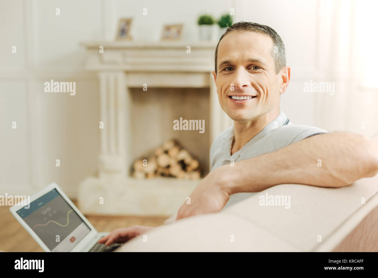 Angenehm positiven Mann das gute Gefühl beim Sitzen und Lächeln Stockfoto
