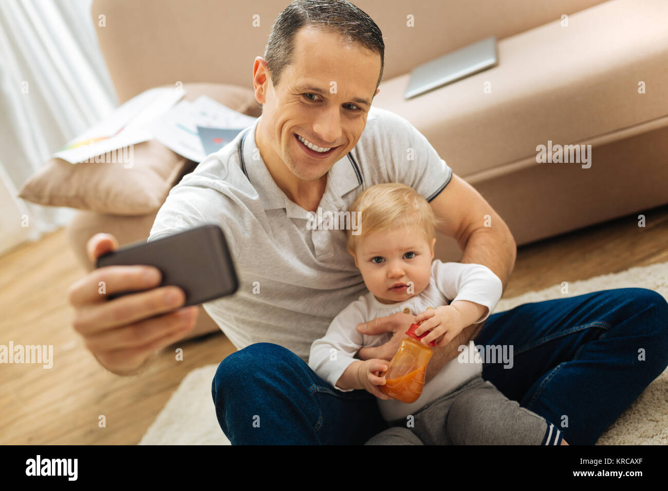 Gerne emotionale Vater und lächelnd ein Kind während der Einnahme von Fotos Stockfoto