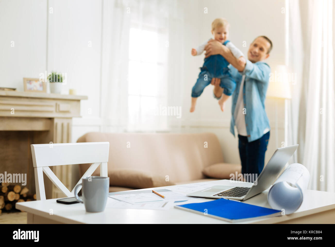 Aufmerksamen freundlichen Vater spielen mit einem Baby, während zu Hause Stockfoto