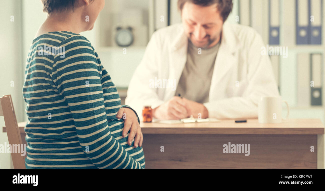 Arzt pillen Verschreibung an schwangere Frau. Gesundheitswesen und Medizin während der Schwangerschaft. Stockfoto