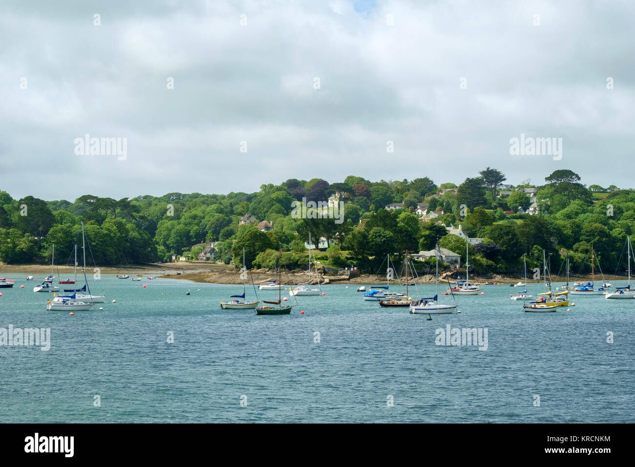 Blick über den malerischen Helford River, wo viele kleine Boote in der Nähe von idyllischen ländlichen Helford Dorf in Cornwall, UK vor Anker liegen. Stockfoto