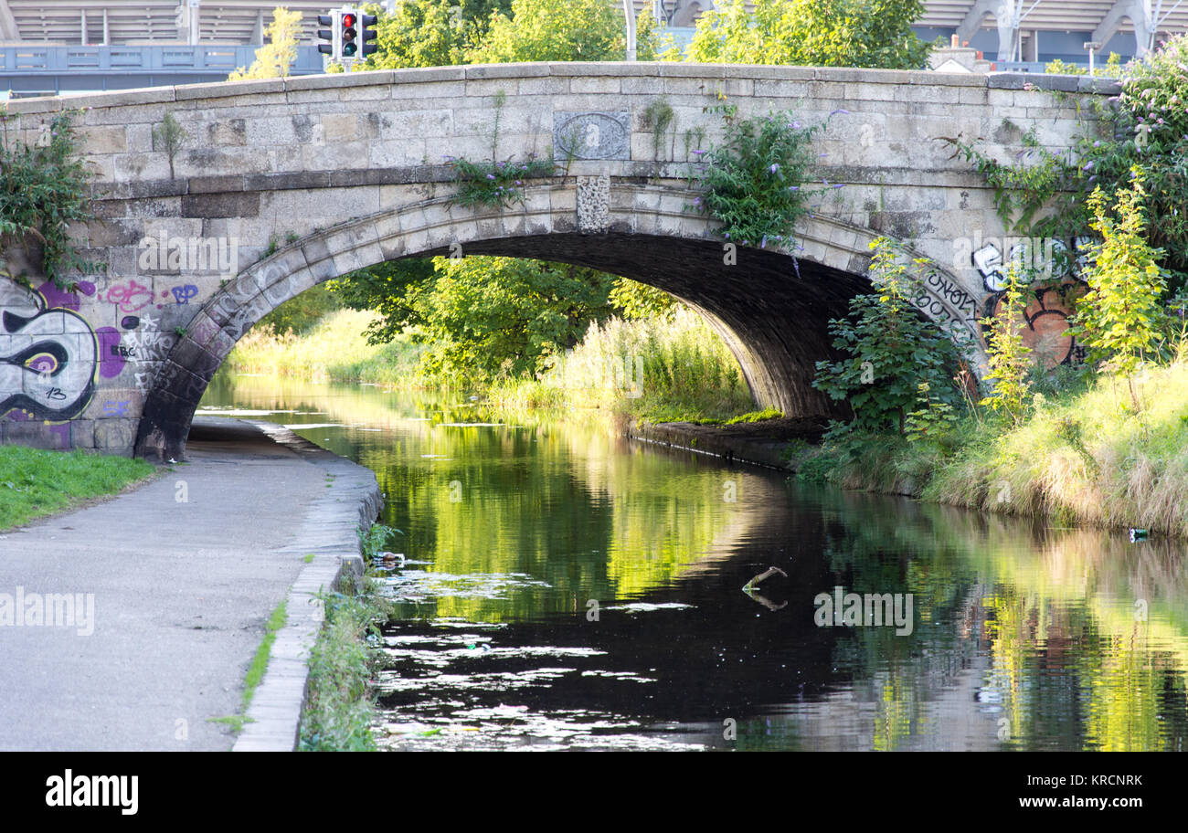 Die Ballybough Road kreuzt Irlands Royal Canal auf einem steinernen Bogenbrücke im Norden Strand Nachbarschaft von Dublin. Stockfoto