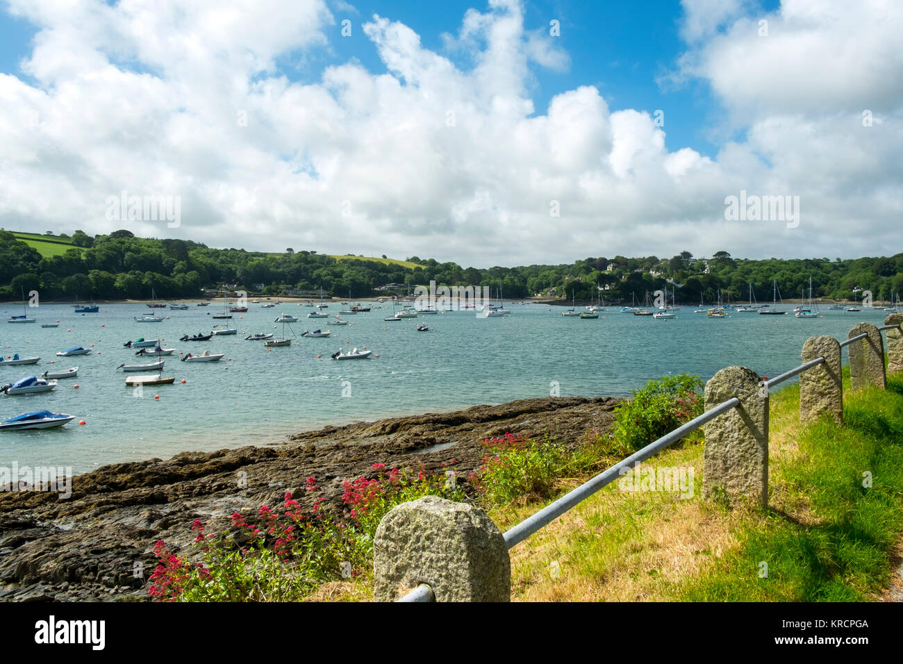 Mit Blick über die malerische Helford River, wo viele kleine Boote zwischen Helford Dorf und Helford Passage in Cornwall, UK vor Anker liegen. Stockfoto