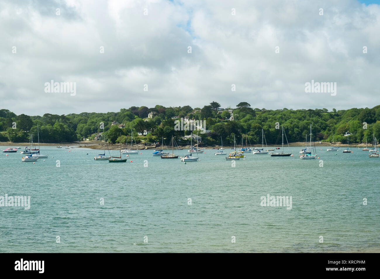 Mit Blick über die malerische Helford River, wo viele kleine Boote zwischen Helford Dorf und Helford Passage in Cornwall, UK vor Anker liegen. Stockfoto