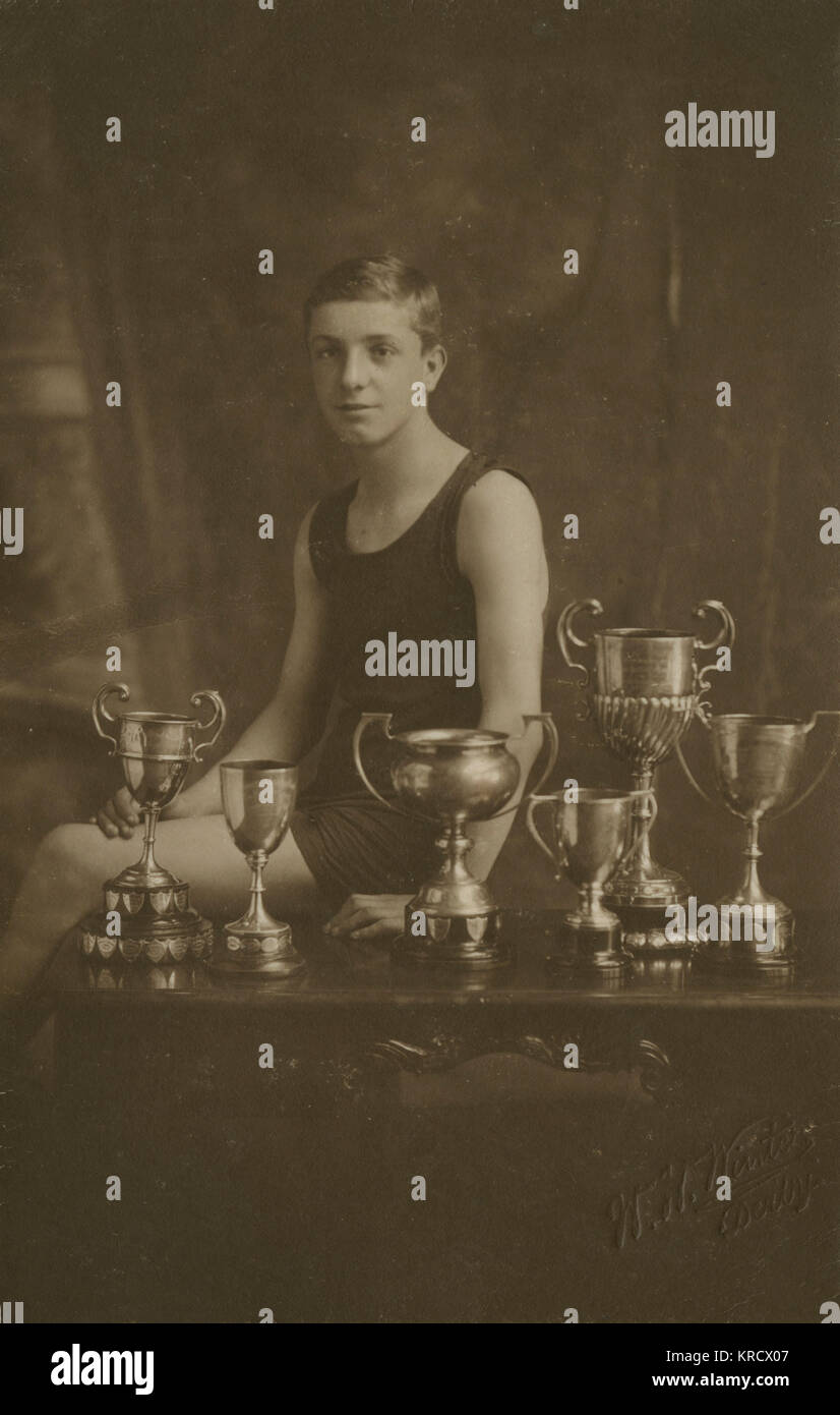 Vierzehnjähriger Schwimmmeister mit Trophäen Stockfoto