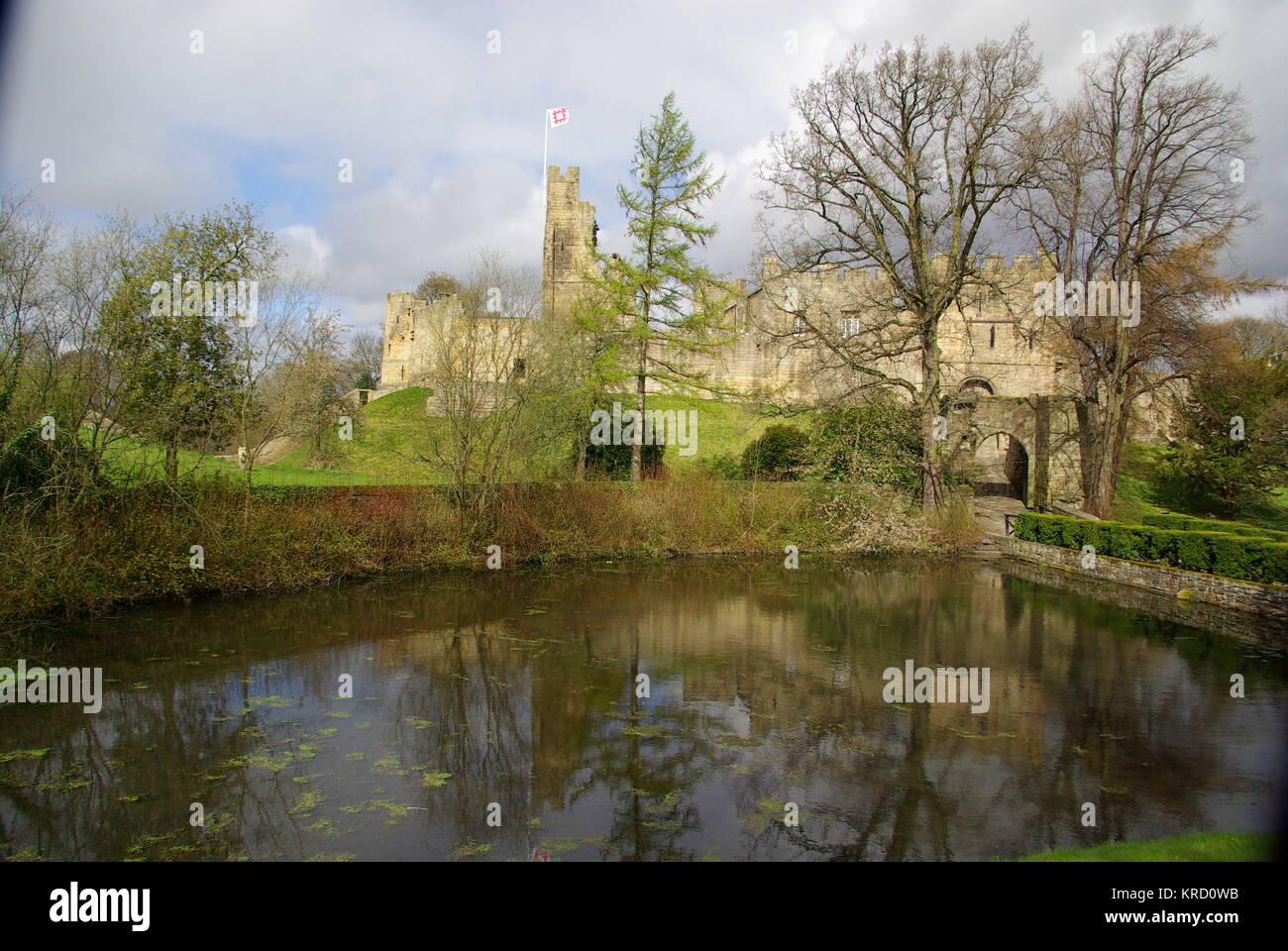 Blick über das Wasser von Prudhoe Castle, Northumberland. Das Gebäude begann im 12. Jahrhundert als Verteidigung gegen schottische Eindringlinge und wurde über die Jahrhunderte ergänzt und restauriert. Stockfoto