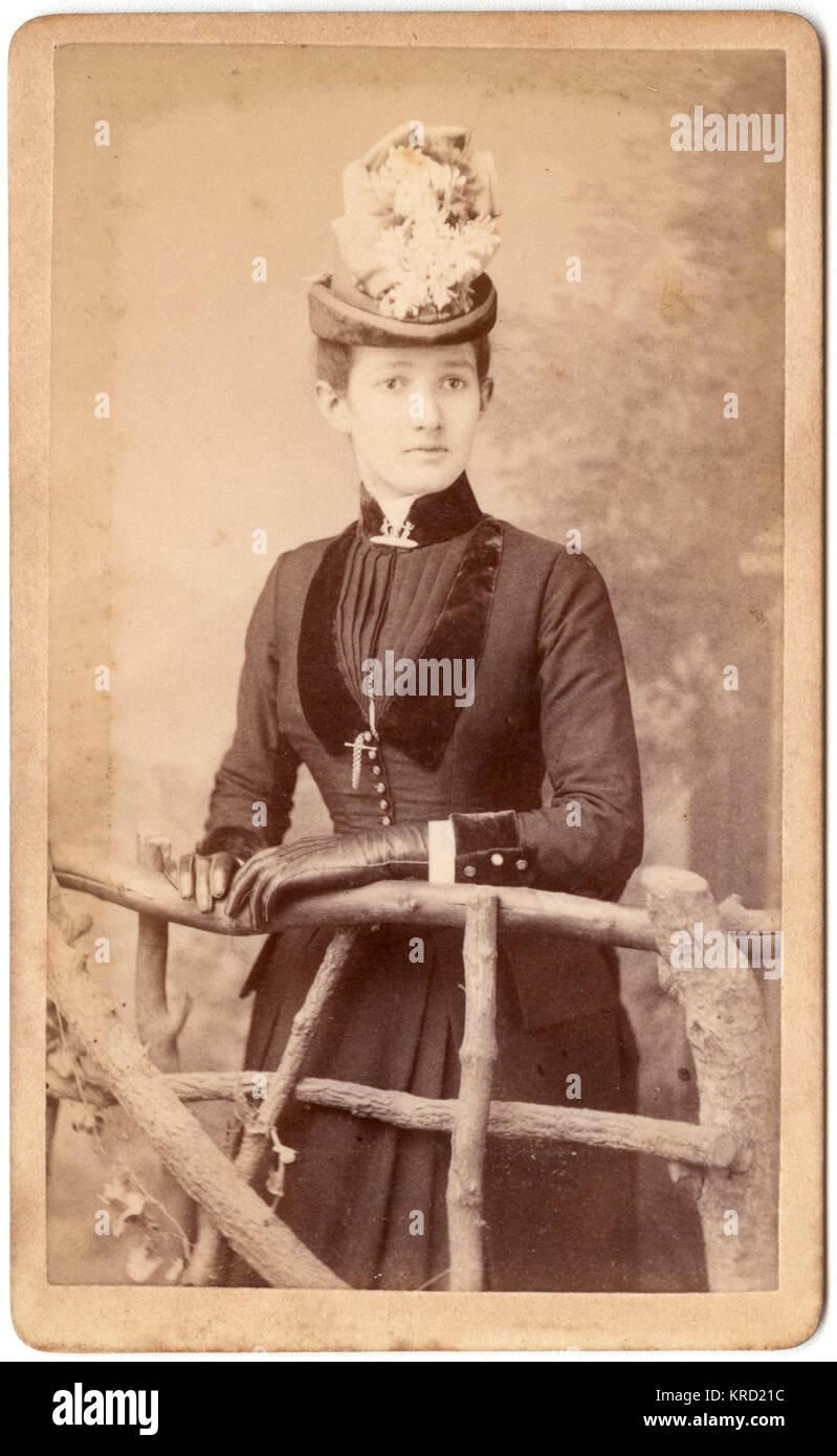 Viktorianische Frau, die hinter einem rustikalen Zaun steht Stockfoto