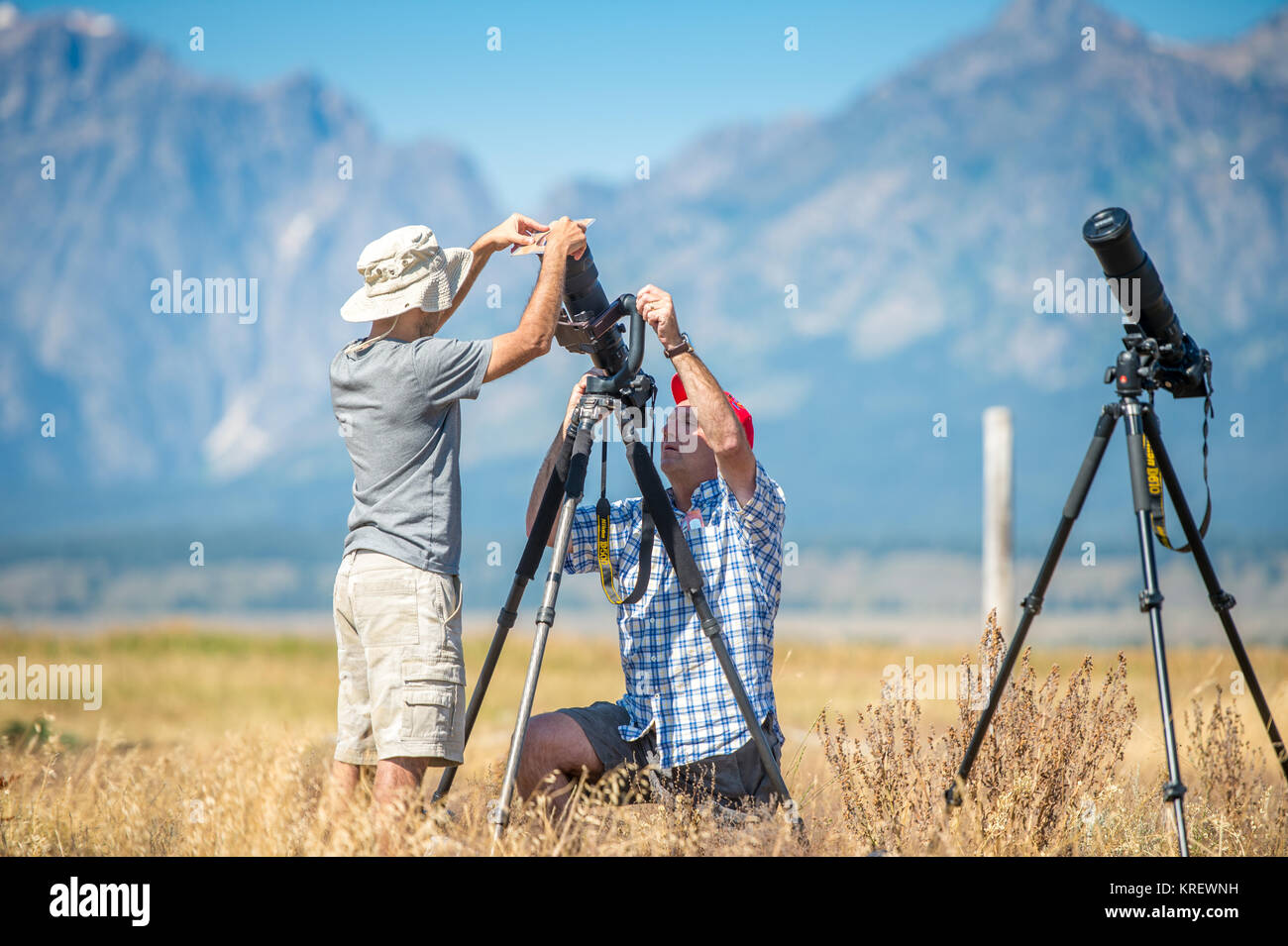 Junge Mann hilft einem anderen männlichen Fotograf seine Kamera, Grand Tetons National Park, Teton County, Wyoming Stockfoto