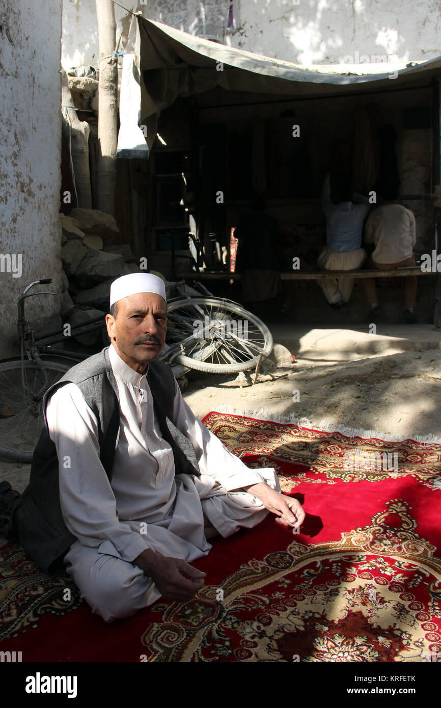 Teppich Weber Samarialai (R) zeigt seine Arbeit an einem handgewebten Teppich in der afghanischen Hauptstadt Kabul, Afghanistan, 28. Oktober 2017. Foto: Christine-Felice Röhrs/dpa Stockfoto