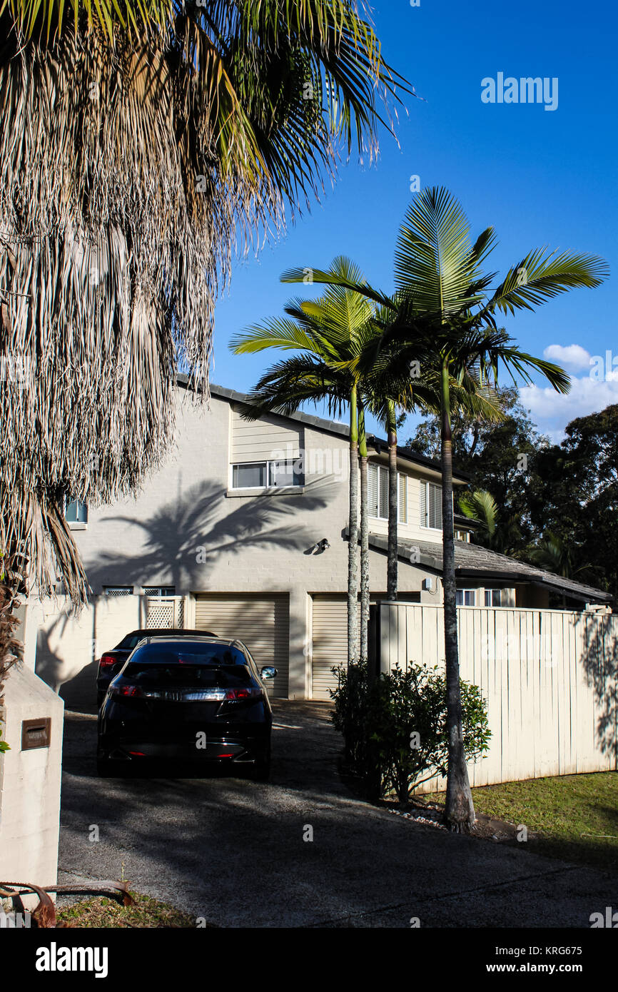 Suburban subtropischen Haus in der Nähe von Brisbane Australien mit aktuellen Bäume dramatische Schatten und zwei Autos in der Auffahrt Stockfoto