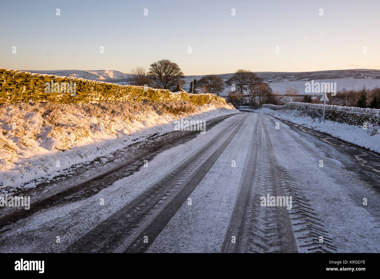 Eisigen Landstraße an einem strahlenden Wintermorgen in Derbyshire, England. Stockfoto