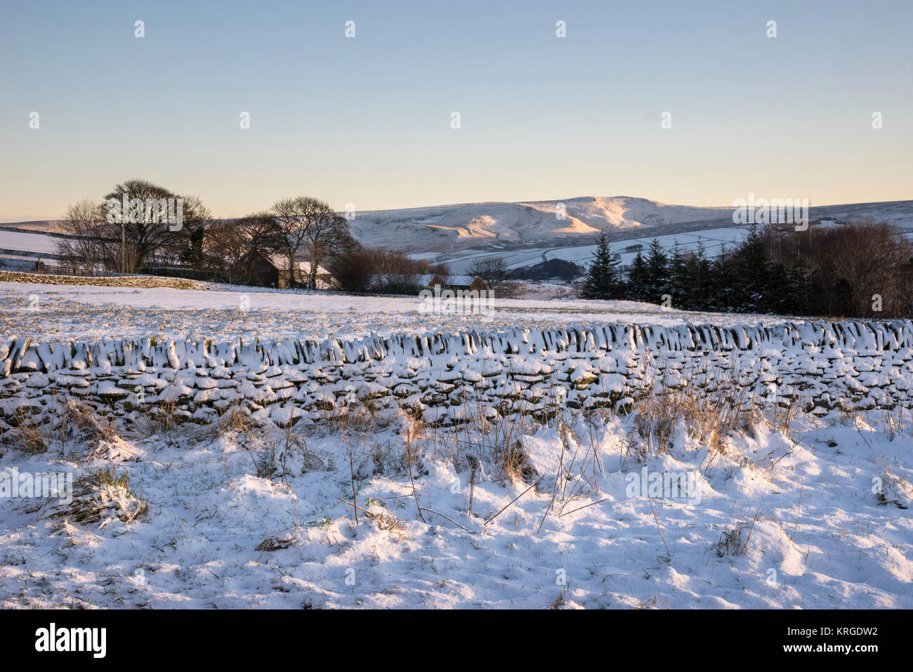 Blick über verschneite Felder auf die fernen Hügel auf einer klaren Wintermorgen. Rowarth, Derbyshire, England. Stockfoto