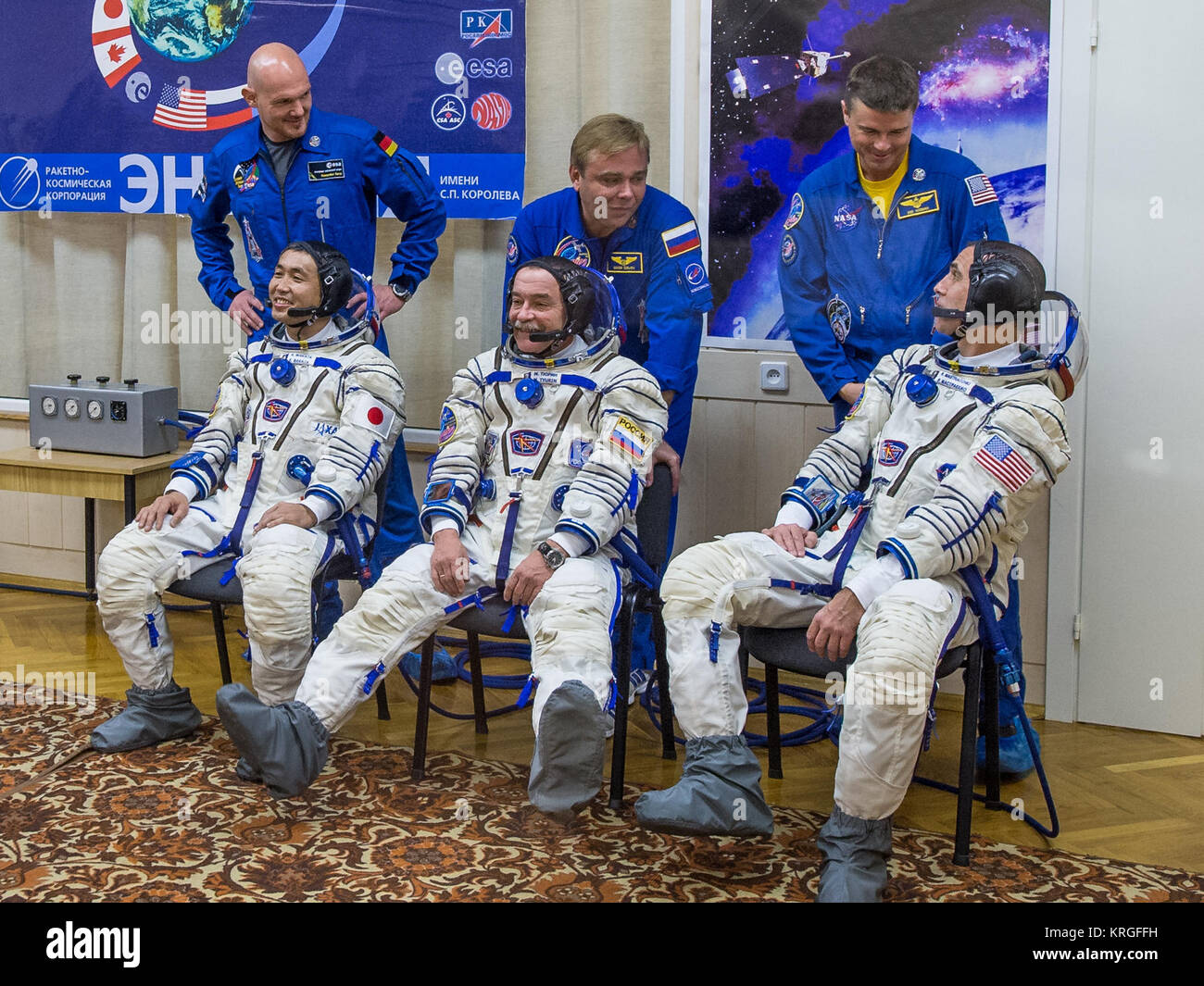 Sitzend von Links nach Rechts, Expedition 38 Bordingenieur Koichi Wakata der Japan Aerospace Exploration Agency, Sojus Commander Mikhail Tyurin von Roskosmos, und Flugingenieur Rick Mastracchio der NASA sind durch Glas zusammen mit Backup Crew Mitglieder gesehen, stand hinter ihnen von Links, Alexander Gerst der Europäischen Weltraumorganisation, der russische Kosmonaut Max Suraev, und Reid Wiseman der NASA, wie Sie die Vorbereitung auf Ihre russischen Sokol Anzüge Druck ein paar Stunden überprüft vor ihrer Markteinführung, Donnerstag, November 7, 2013, in Baikonur, Kasachstan. Tyurin, Wakata und Mastracchio in ihren S starten Stockfoto