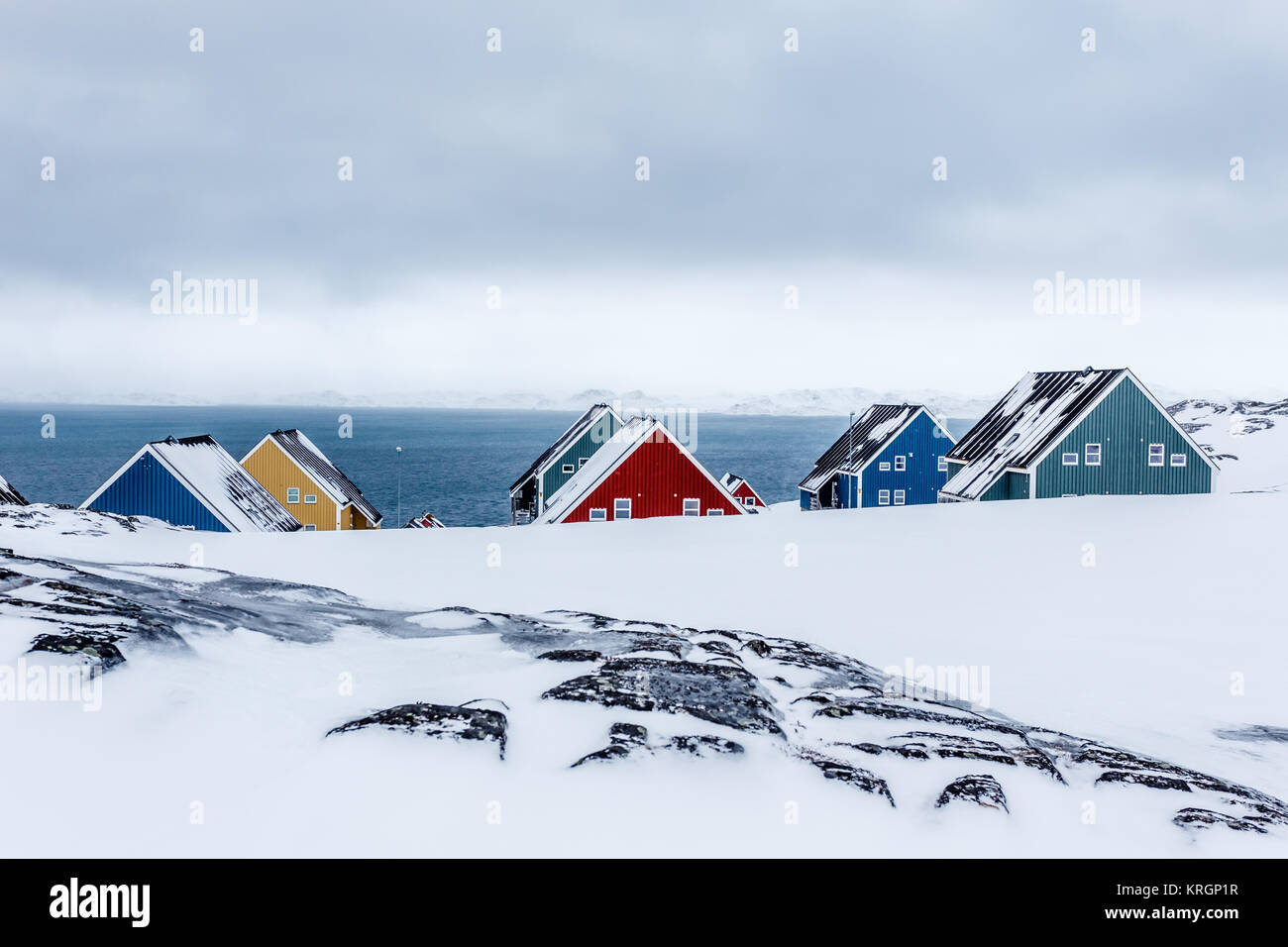 Reihen von bunten Inuit Häuser unter den Felsen in einem Vorort von arktischen Hauptstadt Nuuk, Grönland Stockfoto