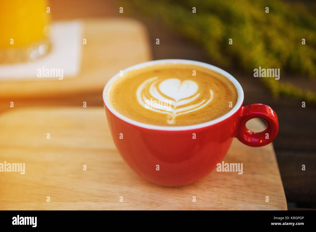 Rote Kaffeetasse in einem Sommertag mit Blumen im Hintergrund Stockfoto