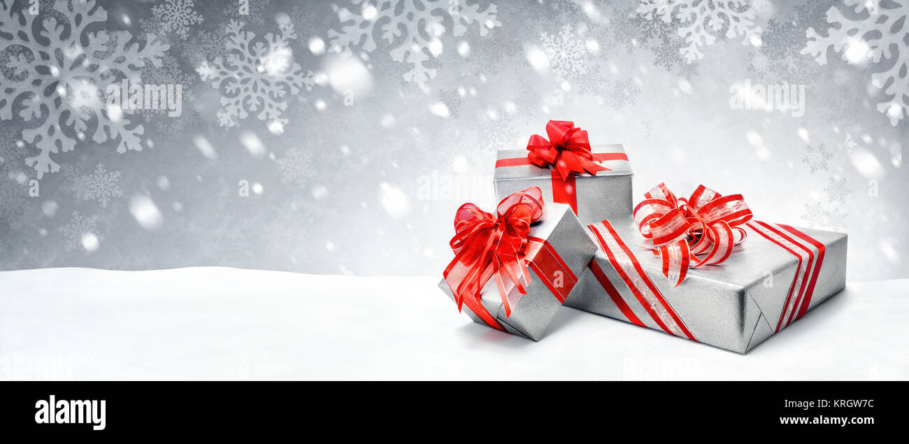 Weihnachten Geschenke in Rot und Silber auf Schnee Hintergrund Stockfoto