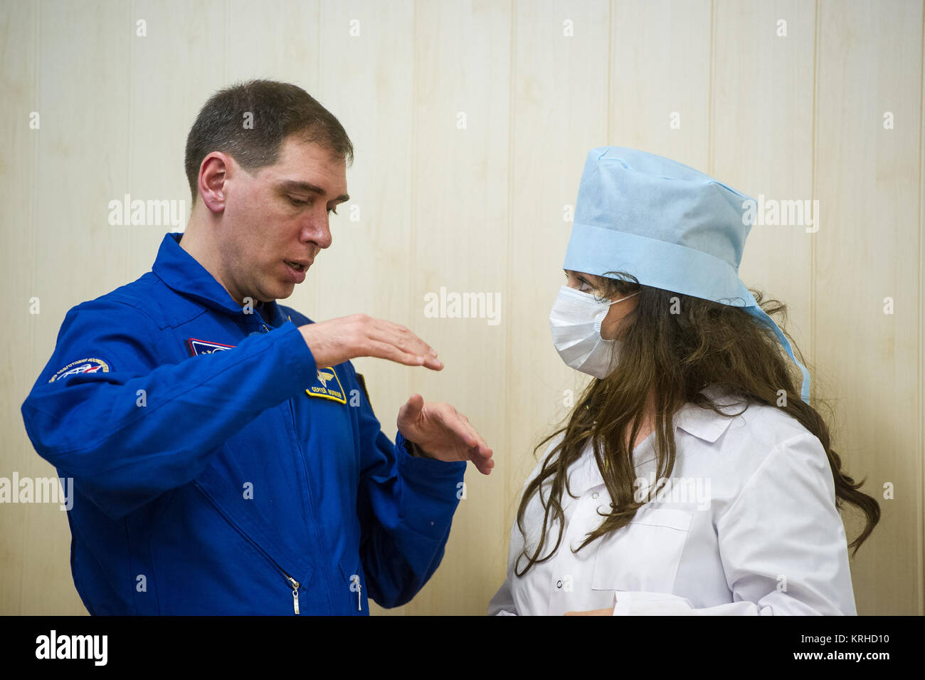 Expedition 43 backup Crew-Mitglied Sergei Volkov von Russlands Federal Space Agency (Roskosmos) erklärt die russische Sokol Anzug Druck prüfen, Sopran-Sängerin Sarah Brightman, geplant, fliegen, Raum später im Jahr 2015 als Raumfahrt Teilnehmer, während NASA Astronaut Scott Kelly, russische Kosmonauten Gennadi Padalka und Mikhail Kornienko der russischen Federal Space Agency (Roskosmos) ihre russische Sokol haben Anzüge Druck überprüft vor ihrem Start an Bord der Sojus TMA - 16 M-Sonde zur internationalen Raumstation ISS Freitag , 27. März 2015 in Baikonor, Kasachstan. Kelly, Padalka, ein Stockfoto