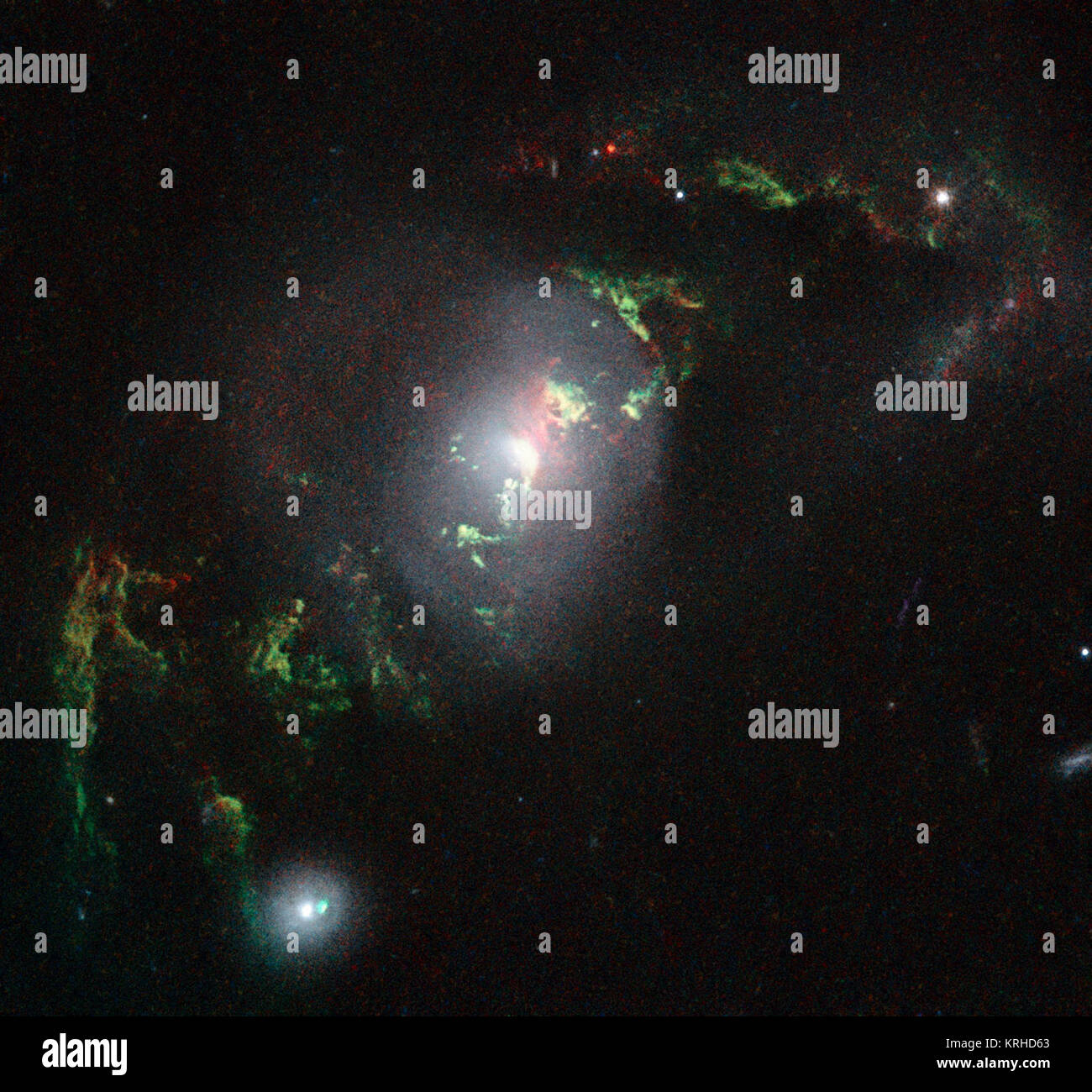 Diese neue NASA/ESA Hubble Space Telescope Bild zeigt Geisterhafte grüne Filamente, liegen innerhalb der Galaxie UGC 7342. Dieser Faden wurde durch einen Knall der Strahlung von einem Quasar beleuchtet - eine sehr helle und kompakte Region, dass das supermassive Schwarze Loch im Zentrum seiner Heimatgalaxie umgibt. Die hellen grünen Farbton ist ein Resultat von ionisiertem Sauerstoff, der Hell in grünen Wellenlängen leuchtet. Heic 1507 e Stockfoto