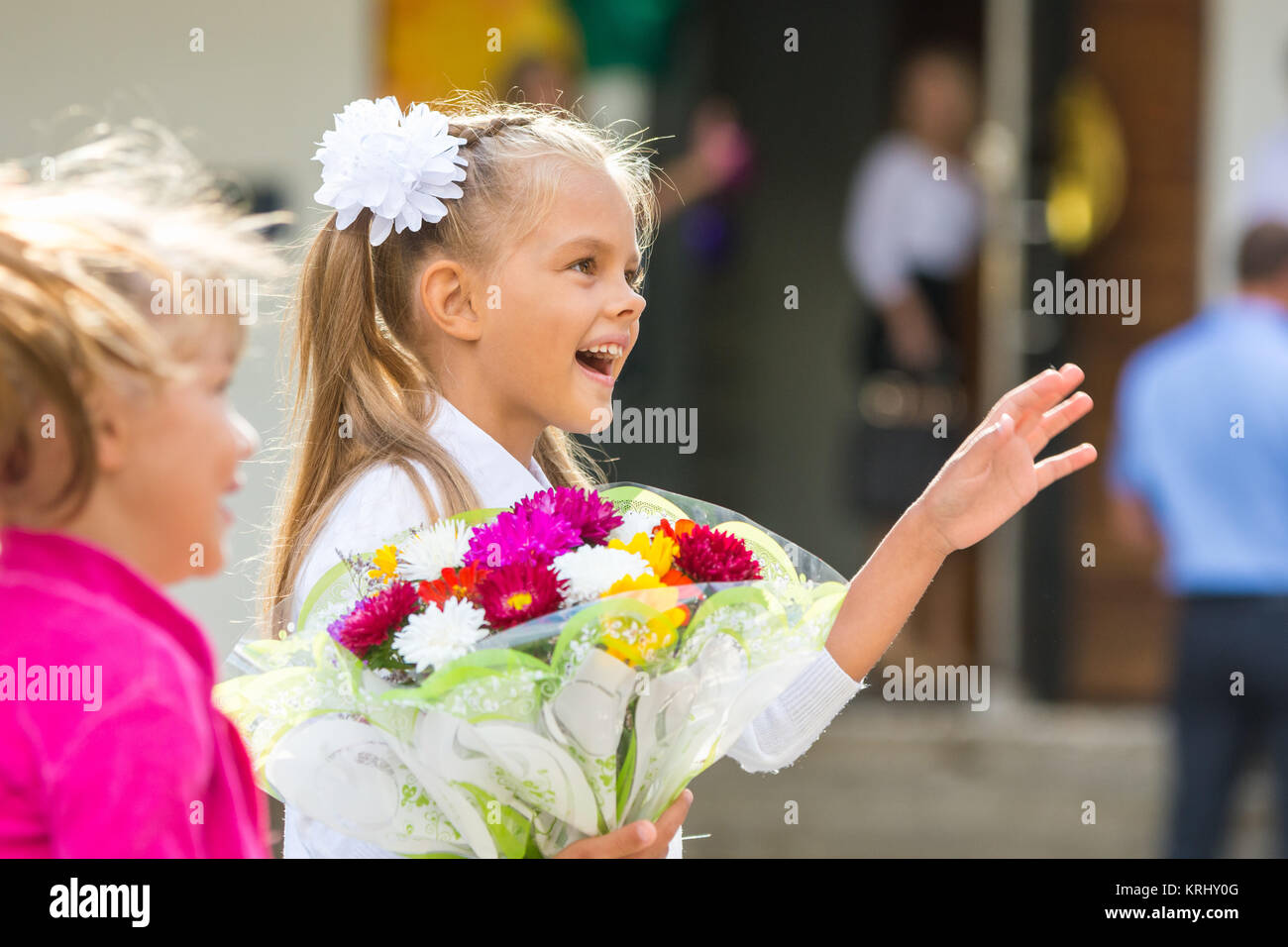 Erste-Grader an der Schule am 1. September in Gruß winken seiner Freundin Stockfoto