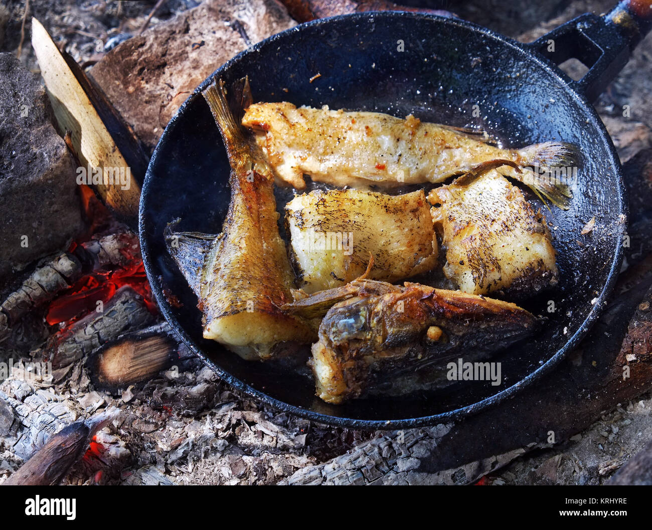 Gebratener Fisch auf dem Feuer in einer Pfanne. Stockfoto