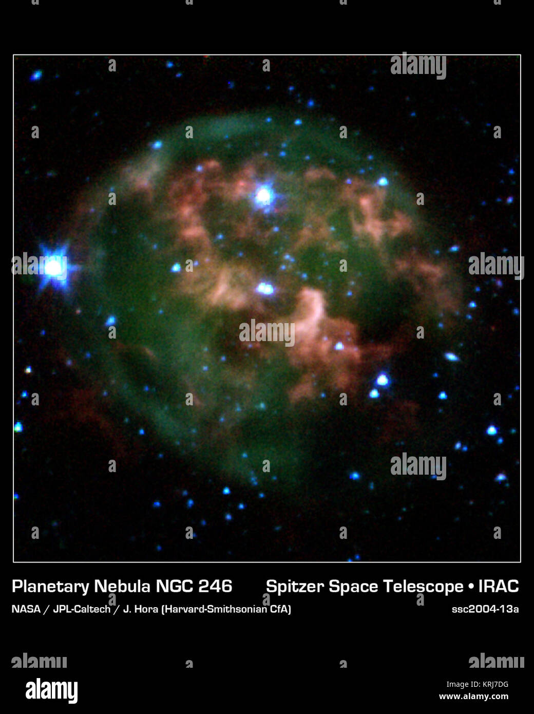 Dieses Bild von NASA's Spitzer Space Telescope zeigt eine sterbende Sterne (Mitte) von einer Wolke aus glühendem Gas und Staub umgeben. Spitzer hat durch den Staub zu markieren eine nie zuvor gesehene Feature - ein riesiger ring Material (rot) leicht versetzt von der Cloud Kern, besteht aus Material, das aus dem alternden Star vertrieben wurde durchbohrt. Der Stern und seine cloud Halo bilden eine "Planetarische Nebel" genannt NGC 246. Wenn ein Stern wie unsere eigene Sonne beginnt der Kraftstoff zu laufen, sein Kerngeschäft schrumpft und heizt, kocht die äußeren Schichten des Sterns. Übrig gebliebene Material schiesst nach Außen, die Erweiterung in Tanks um Stockfoto