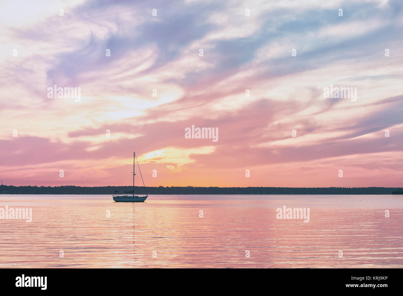 Segelboot auf einen ruhigen Fluß während Bunte sunrise Stockfoto