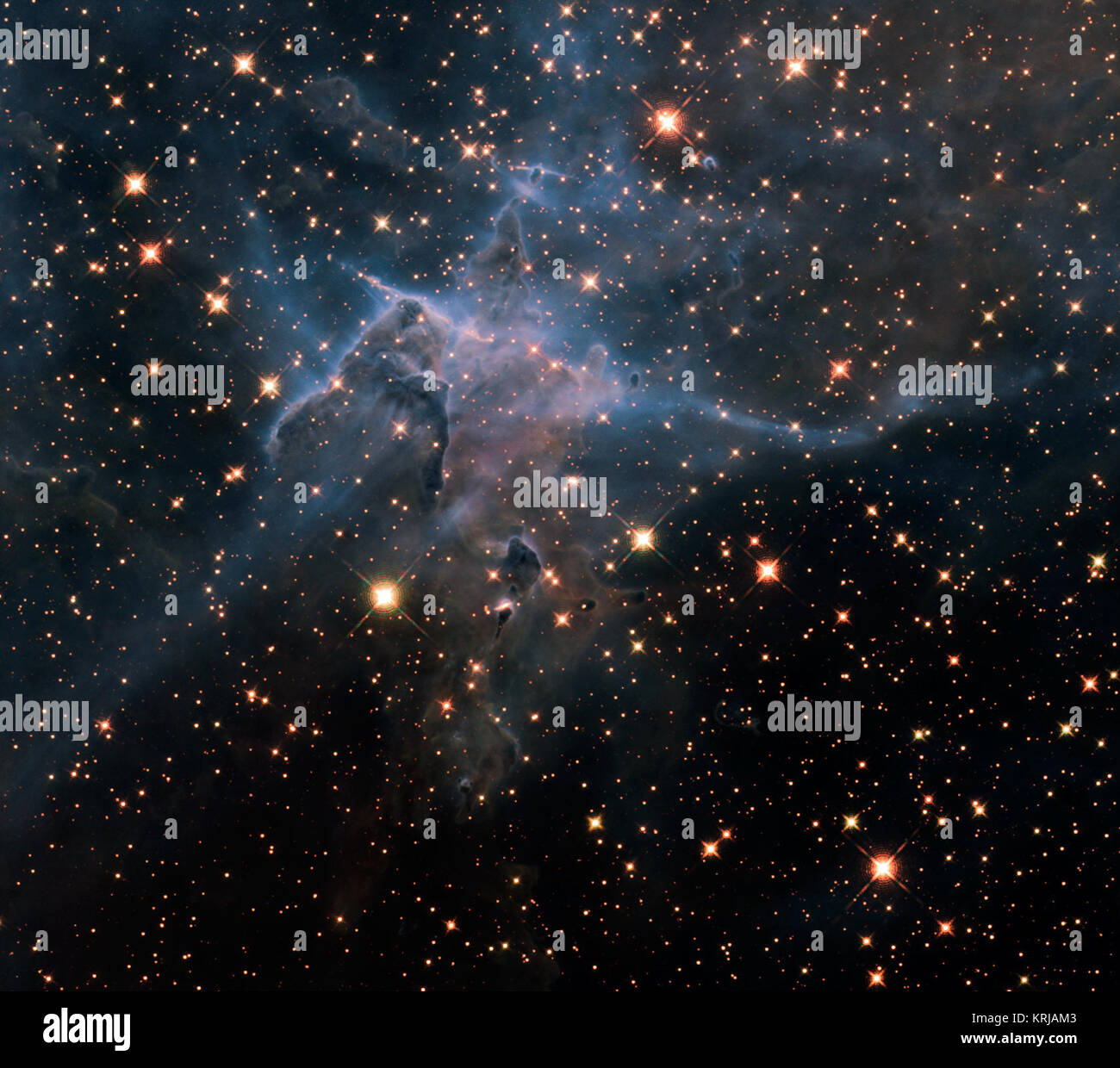 NASA IMAGE release April 23, 2010 Dies ist eine NASA-Hubble-Weltraumteleskop in der Nähe - IR-Licht Bild von drei - Licht - hohen Säule aus Gas und Staub, die sich von den brillanten Licht in der Nähe von Sternen in der stürmischen stellare Kinderstube die Carina Nebula, entfernt 7.500 Lichtjahren im südlichen Sternbild Carina genannt gegessen wird. Das Bild markiert den 20. Jahrestag von Hubbles starten und die Bereitstellung in einer Umlaufbahn um die Erde. Das Bild zeigt eine Fülle von Stars hinter den gasförmigen Schleier der Wand des Nebels von Wasserstoff, geschnürt mit Staub. Im Vordergrund Säule wird semi-transpa Stockfoto