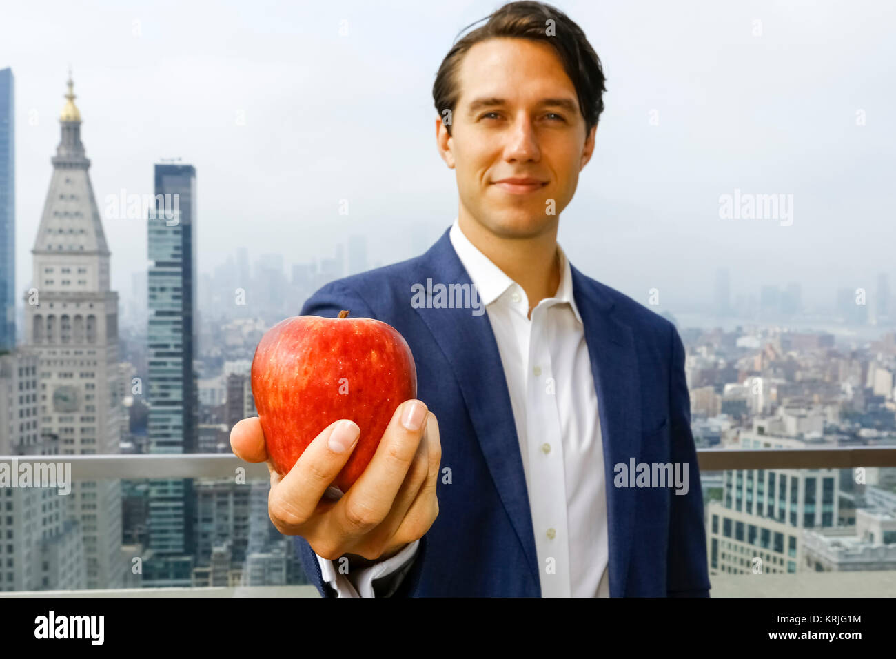 Kaukasische Geschäftsmann zeigt Apple auf der Dachterrasse Stockfoto