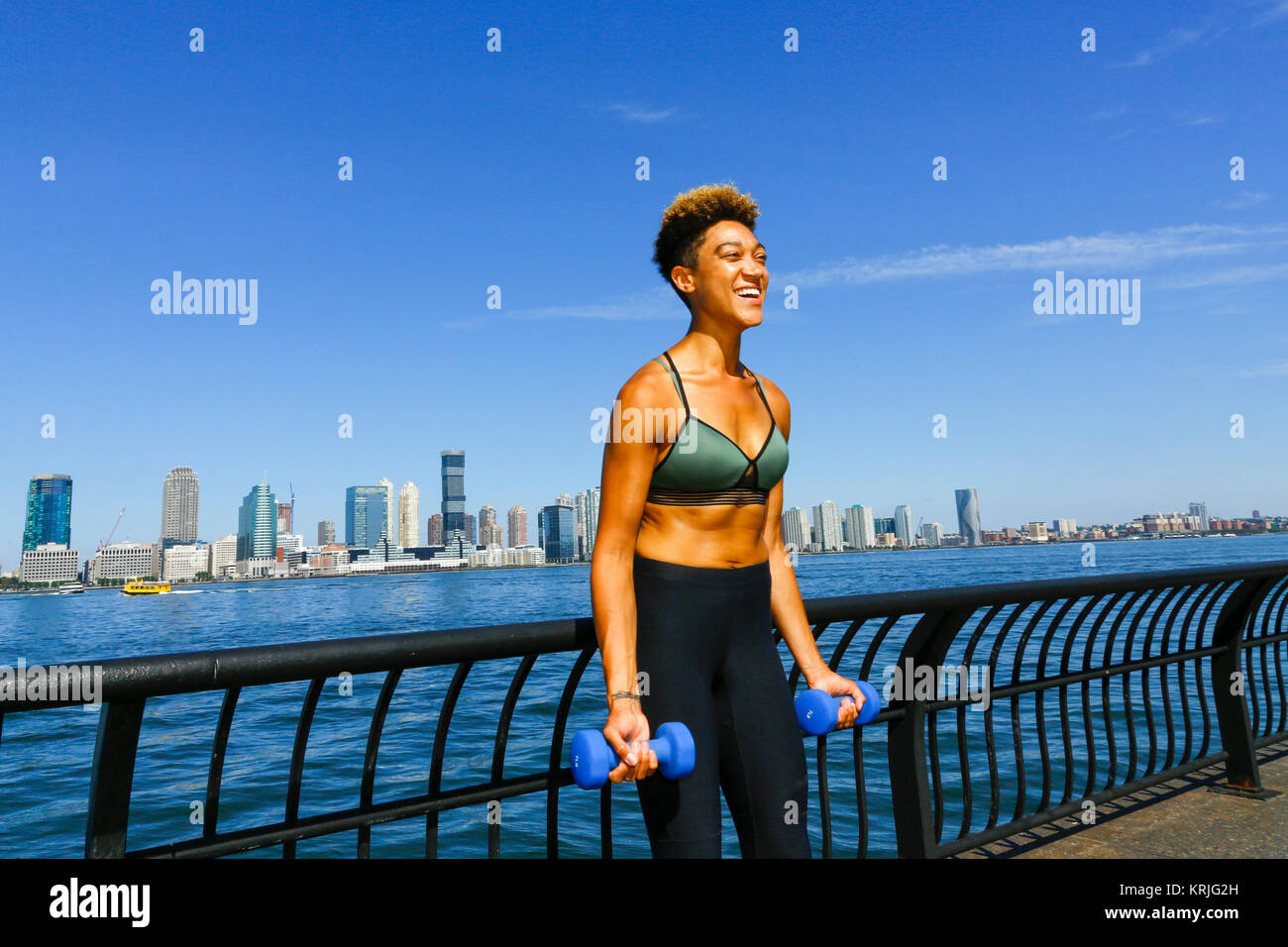 Gemischte Rasse Frau Hanteln im Waterfront Stockfoto