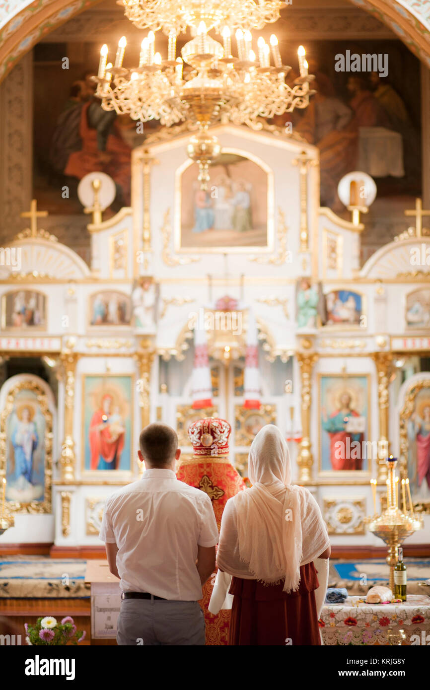 Paar und Priester in der Kirche Stockfoto